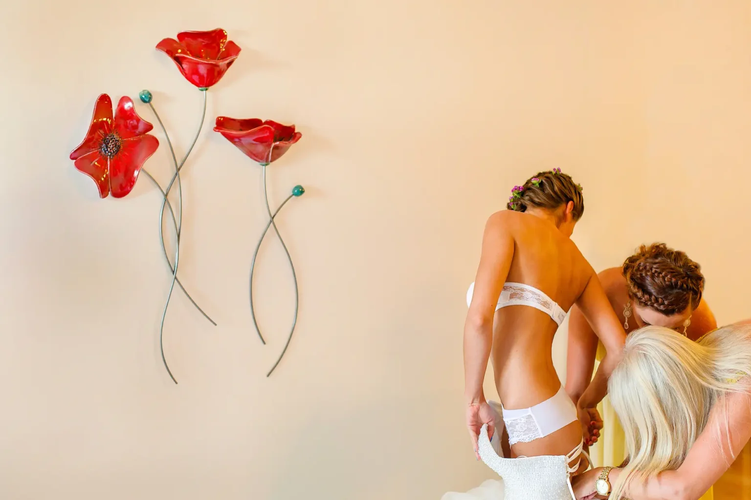 a woman putting on a white dress