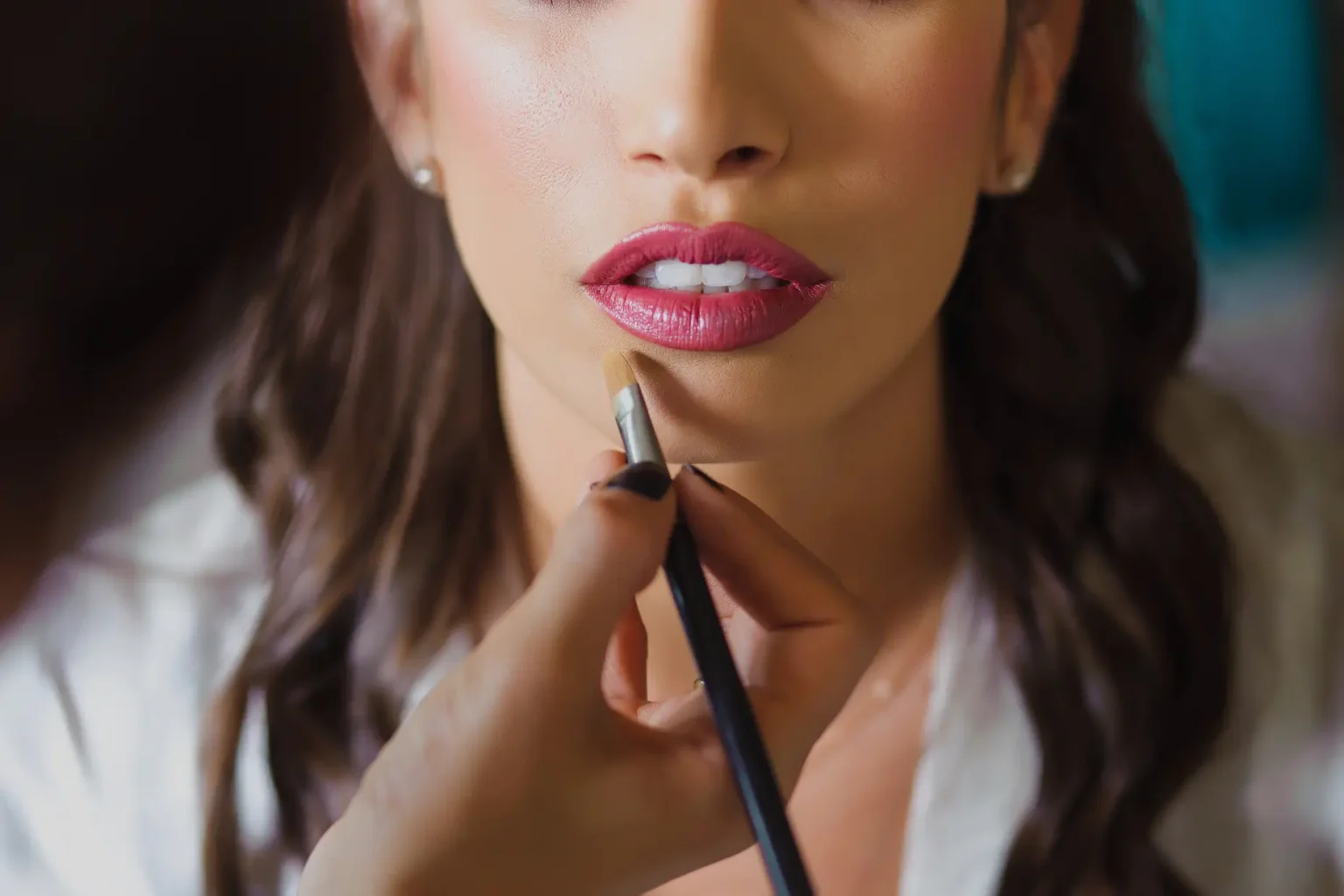 a woman applying lipstick on her lips