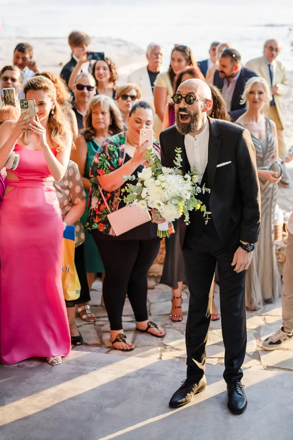 a man in a suit taking a selfie with a woman in a crowd